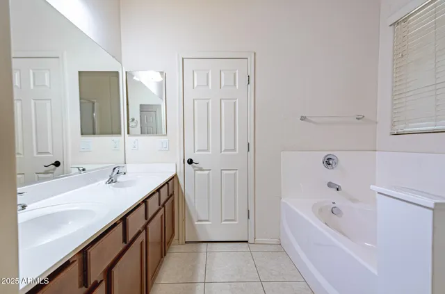 a bathroom with a tub sink and mirror