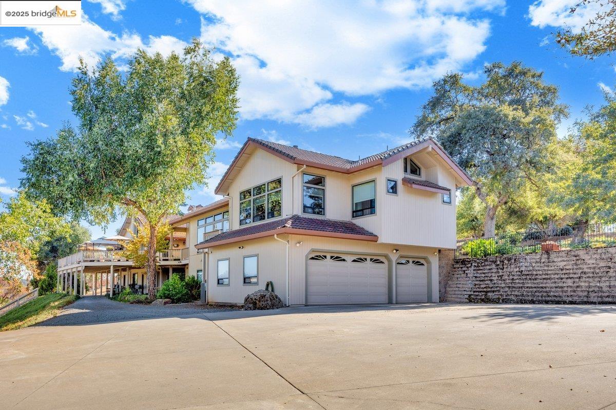 13700 Clements Road Groveland, CA 95321 - Photo 61 of 93 View of front of house with an attached garage, concrete driveway, a tile roof, and stucco siding