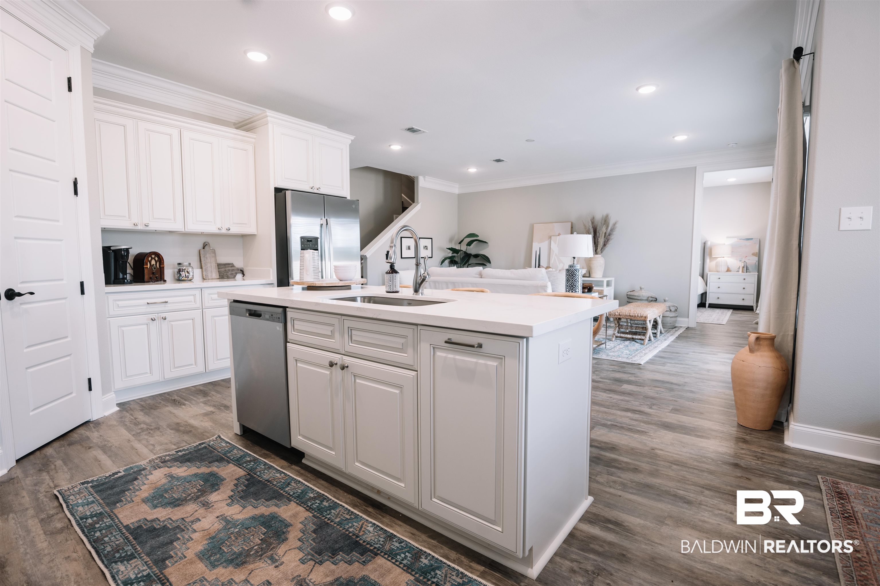 12894 Flanagan Street Elberta, AL 36530 - Photo 15 of 29 Kitchen with white cabinetry, appliances with stainless steel finishes, a kitchen island with sink, dark wood-type flooring, and sink