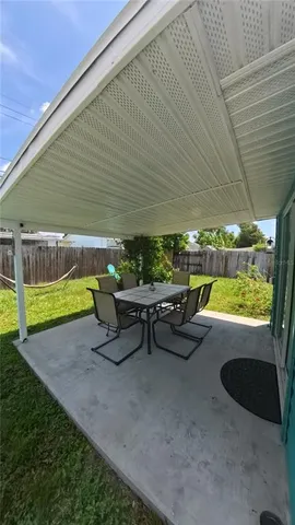a view of patio with table and chairs under an umbrella