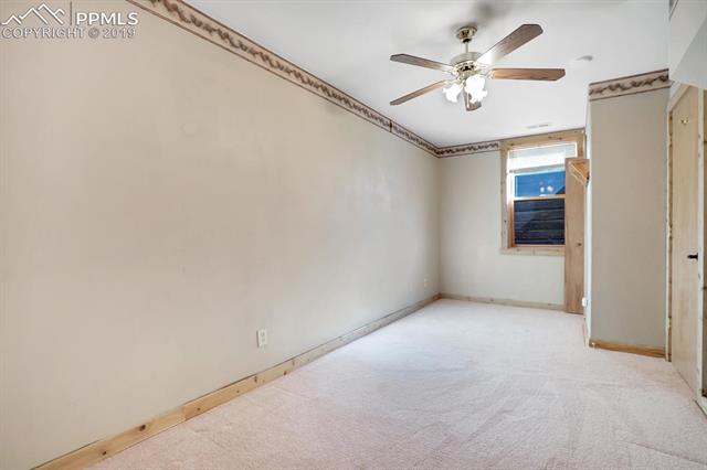 405 Cochetopa Road Florissant, CO 80816 - Photo 25 of 28 Another view of the 4th bedroom with ceiling fan, pine baseboards and closet.
