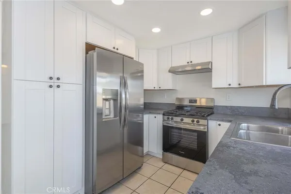 a kitchen with stainless steel appliances granite countertop a stove a refrigerator and a sink