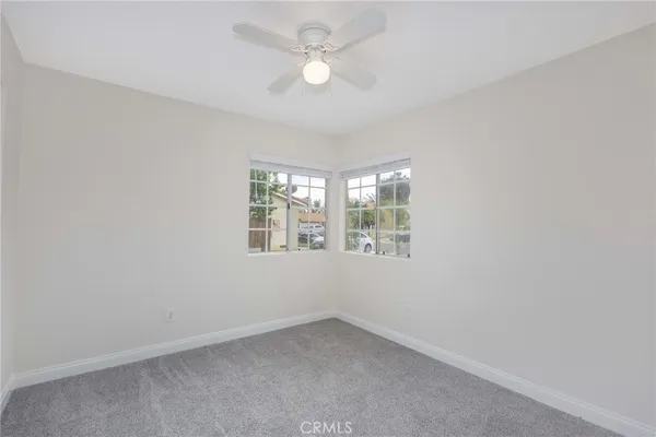 an empty room with a window and a fan