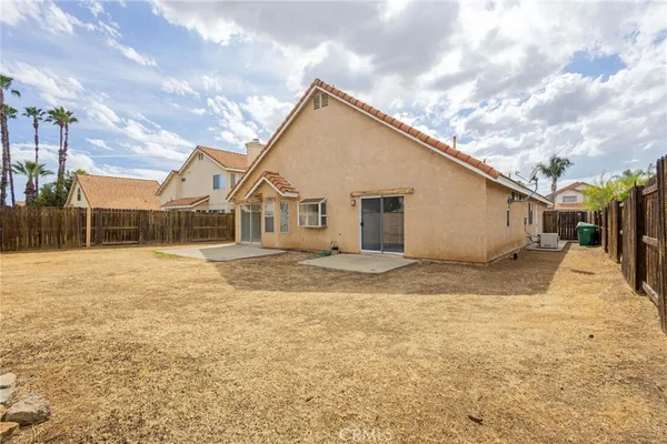 a view of a house with backyard and a tree