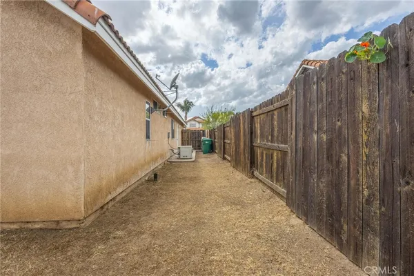 a view of a pathway of a house with wooden fence