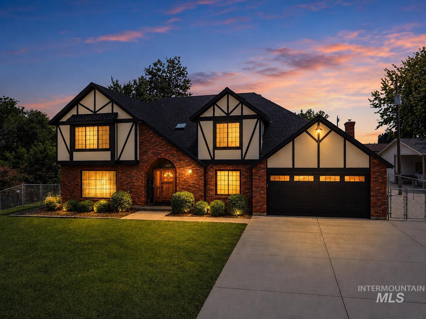 127 Ruth Lane Nampa, ID 83686 - Photo 1 of 49 Brick and stucco exterior with dark trim accents, arched entry with a wood door, multiple gables, and an attached two-car garage