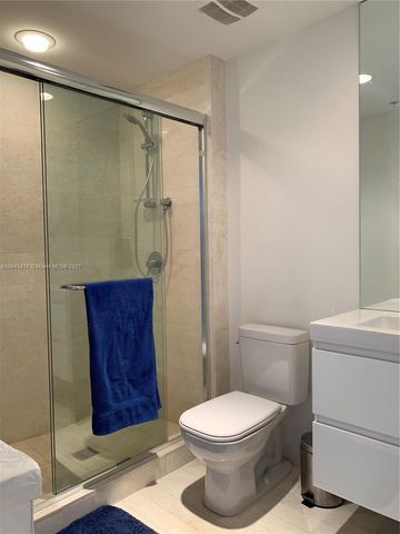 a bedroom with a bed and a potted plant on the dresser