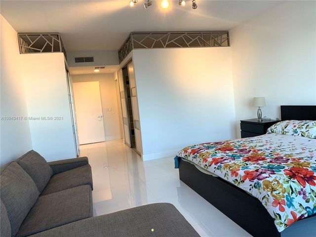 a living room with furniture gaming tables and a chandelier