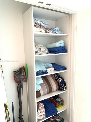 a kitchen with stainless steel appliances kitchen island granite countertop a sink and white cabinets