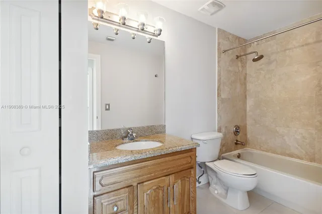a bathroom with a granite countertop toilet a sink and a mirror