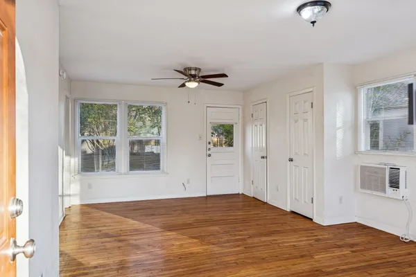 a view of a livingroom with wooden floor and a ceiling fan