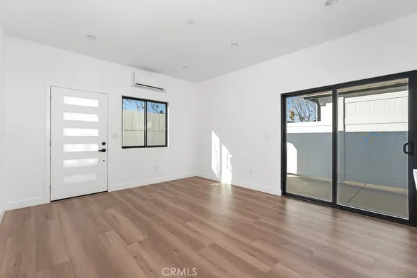 an empty room with mirror and windows
