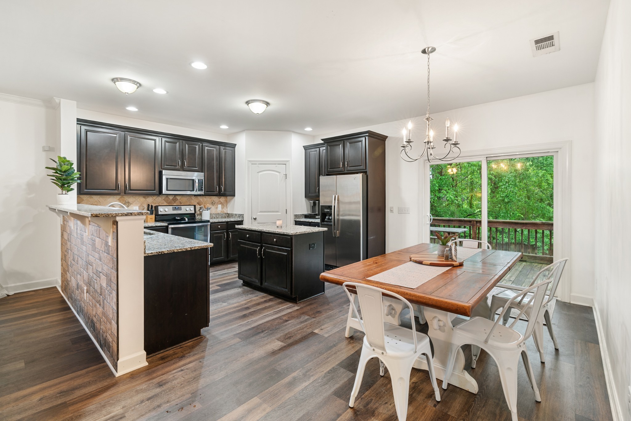 2014 Morton Drive Spring Hill, TN 37174 - Photo 16 of 44 a kitchen with stainless steel appliances kitchen island granite countertop a refrigerator a stove top oven a sink dishwasher a dining table and chairs with wooden floor