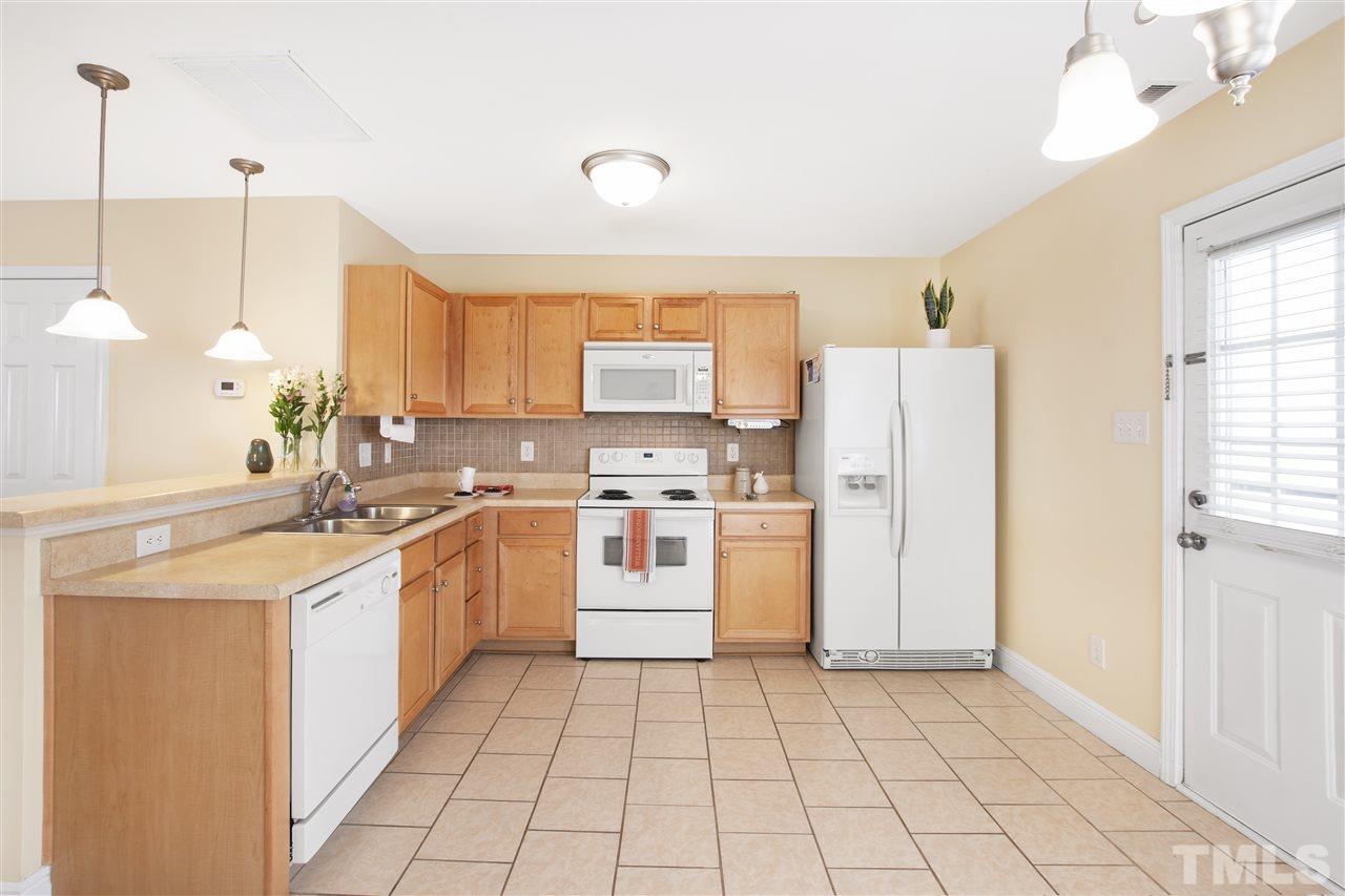 8918 Thornton Garden Lane Raleigh, NC 27616 - Photo 9 of 26 a kitchen with a sink a counter top space and cabinets