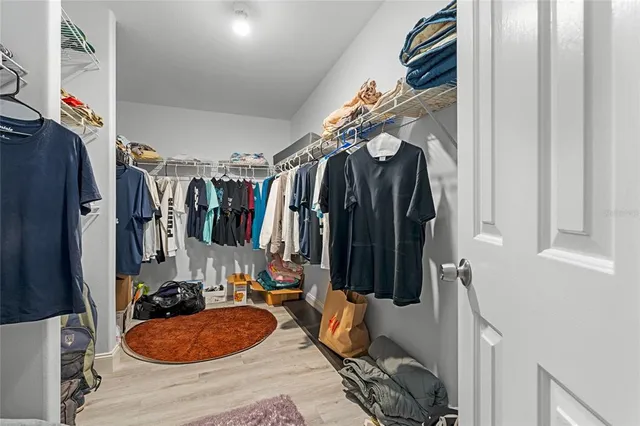 a view of walk in closet with clothes and shoes
