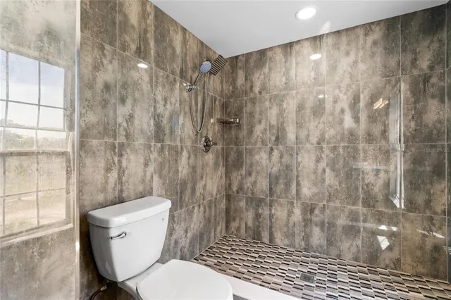 a white toilet sitting next to a shower
