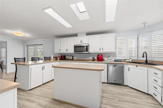 a kitchen with sink a microwave and cabinets