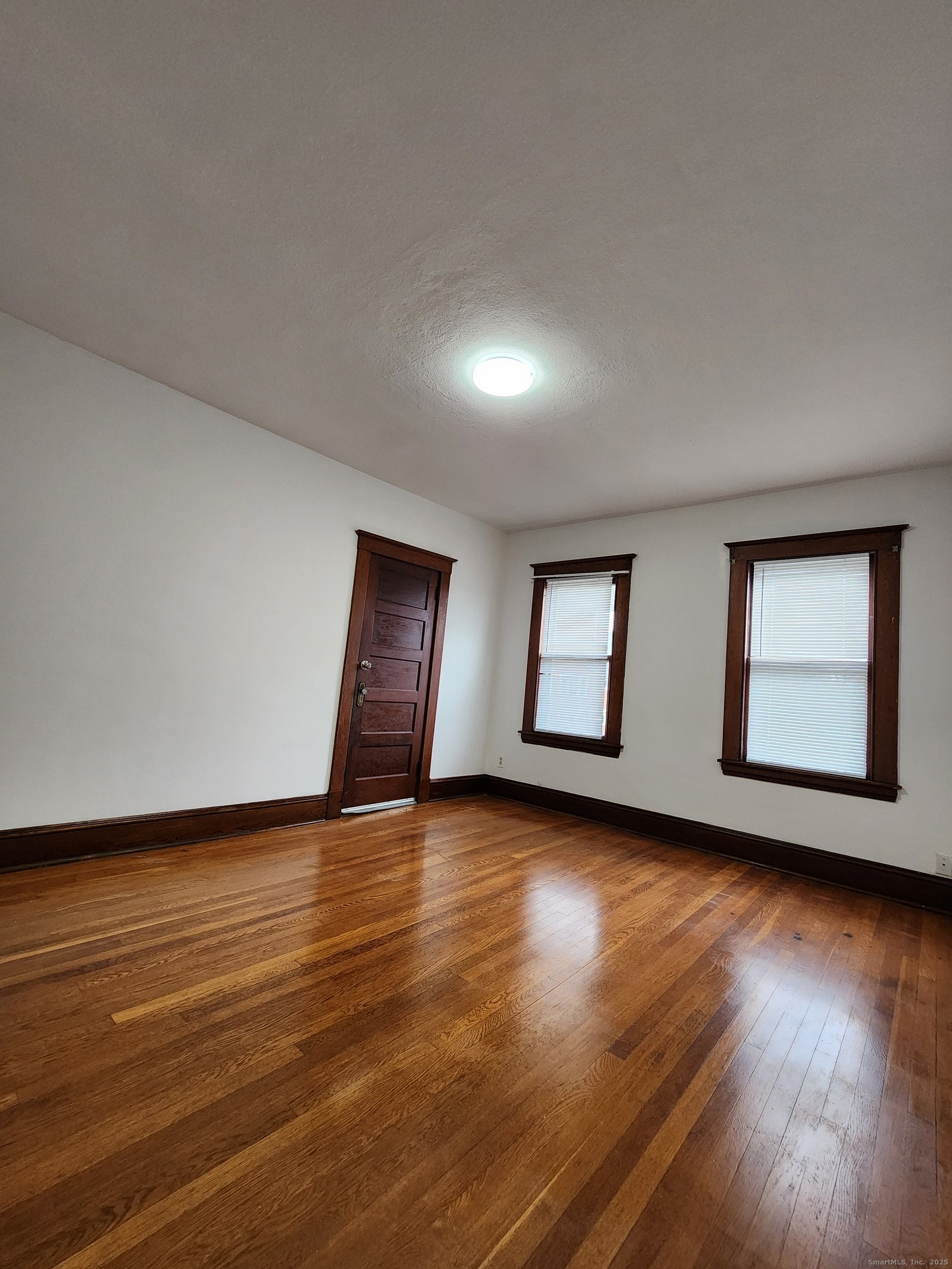106 Lyons Street New Britain, CT 06052 - Photo 13 of 24 a view of an empty room with wooden floor and a window