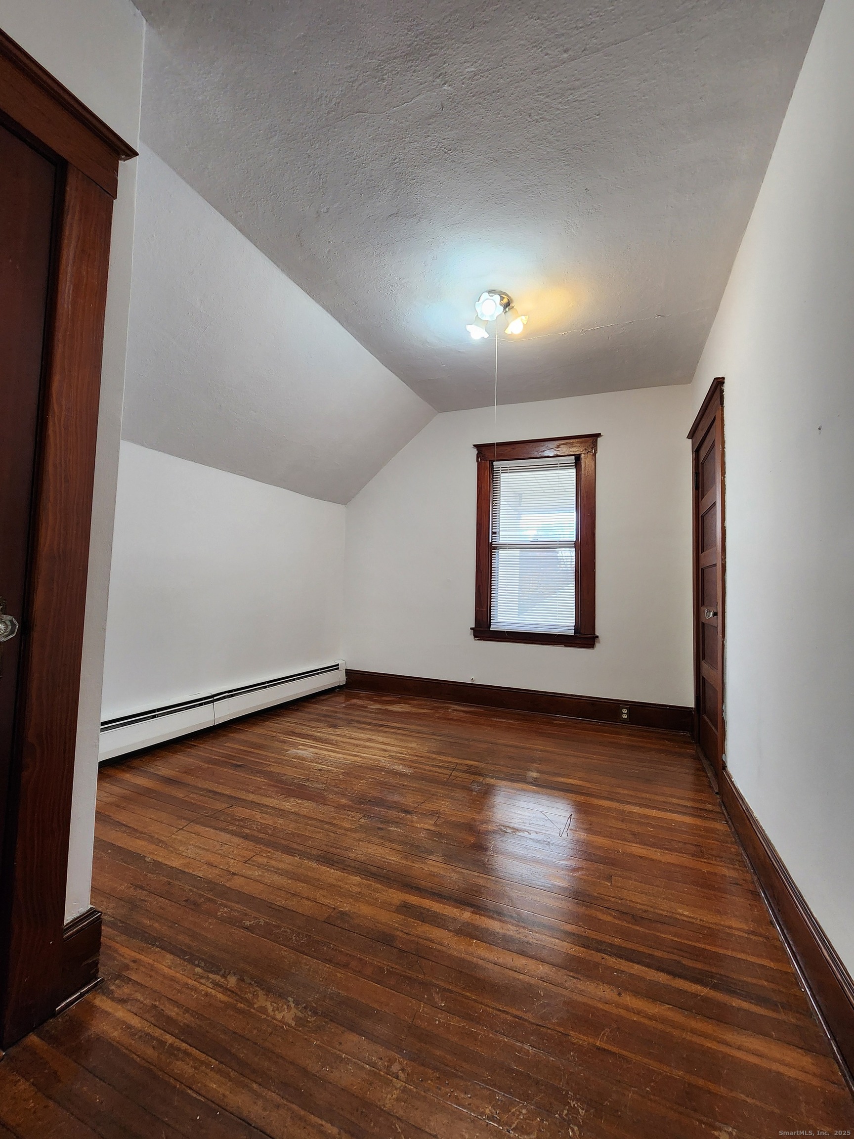 106 Lyons Street New Britain, CT 06052 - Photo 14 of 24 an empty room with wooden floor and windows