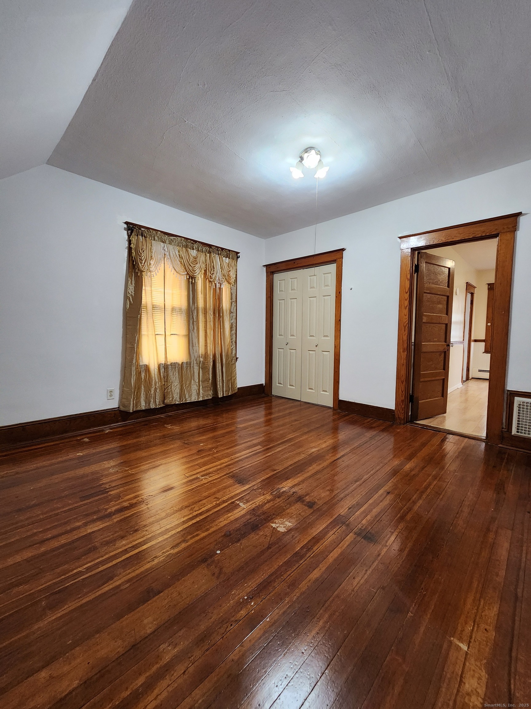 106 Lyons Street New Britain, CT 06052 - Photo 16 of 24 an empty room with wooden floor and windows