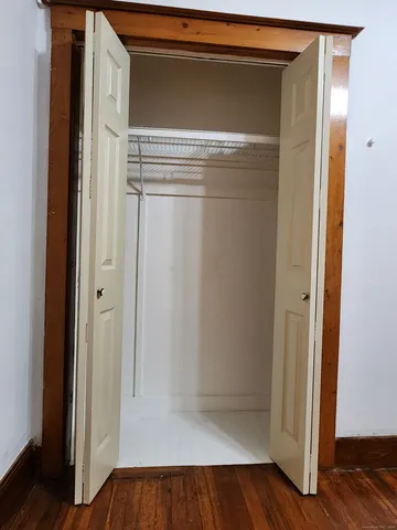 a view of walk in closet with wooden floor