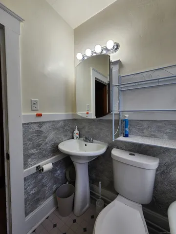 a bathroom with a toilet sink and mirror