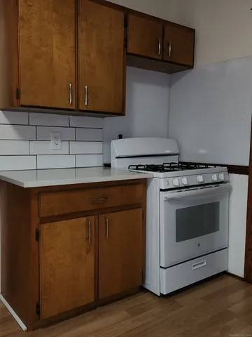 a kitchen with granite countertop cabinets stainless steel appliances and wooden floor