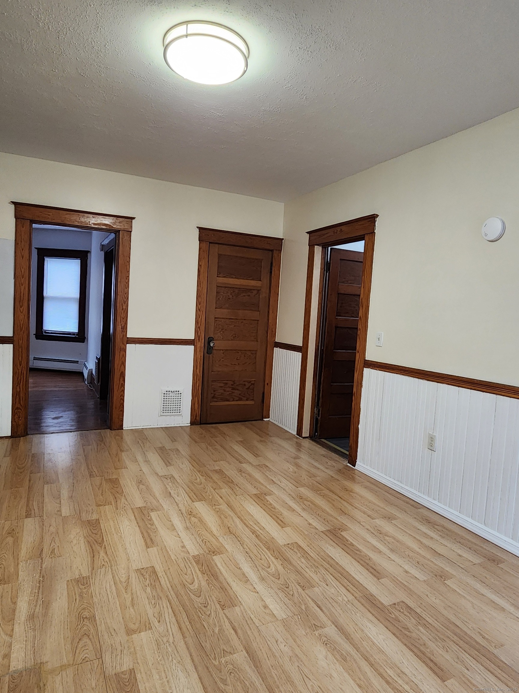 106 Lyons Street New Britain, CT 06052 - Photo 7 of 24 a view of empty room with wooden floor and fan