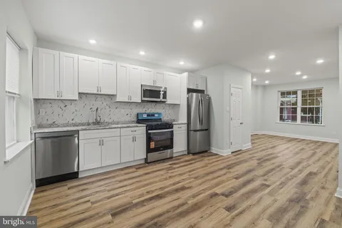 a kitchen with stainless steel appliances granite countertop a refrigerator sink and stove