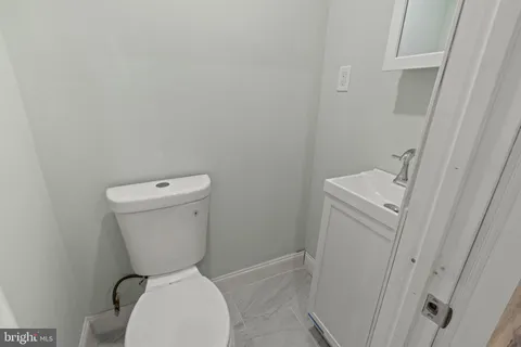a white toilet sitting next to a white cabinet