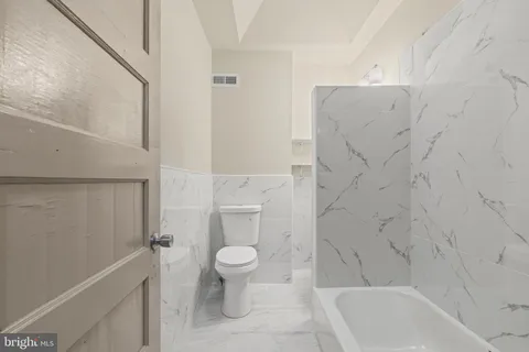 a bathroom with a toilet and a bathtub