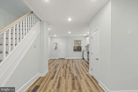 a view of a hallway with wooden floor and staircase
