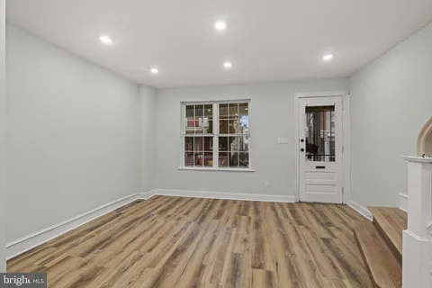 a view of a bedroom with wooden floor and window