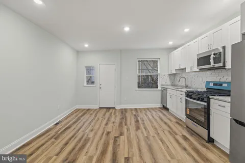 a kitchen with granite countertop a stove top oven and sink