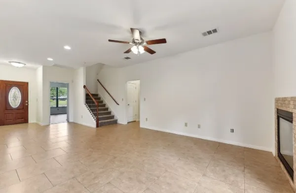 an empty room with wooden floor and staircase