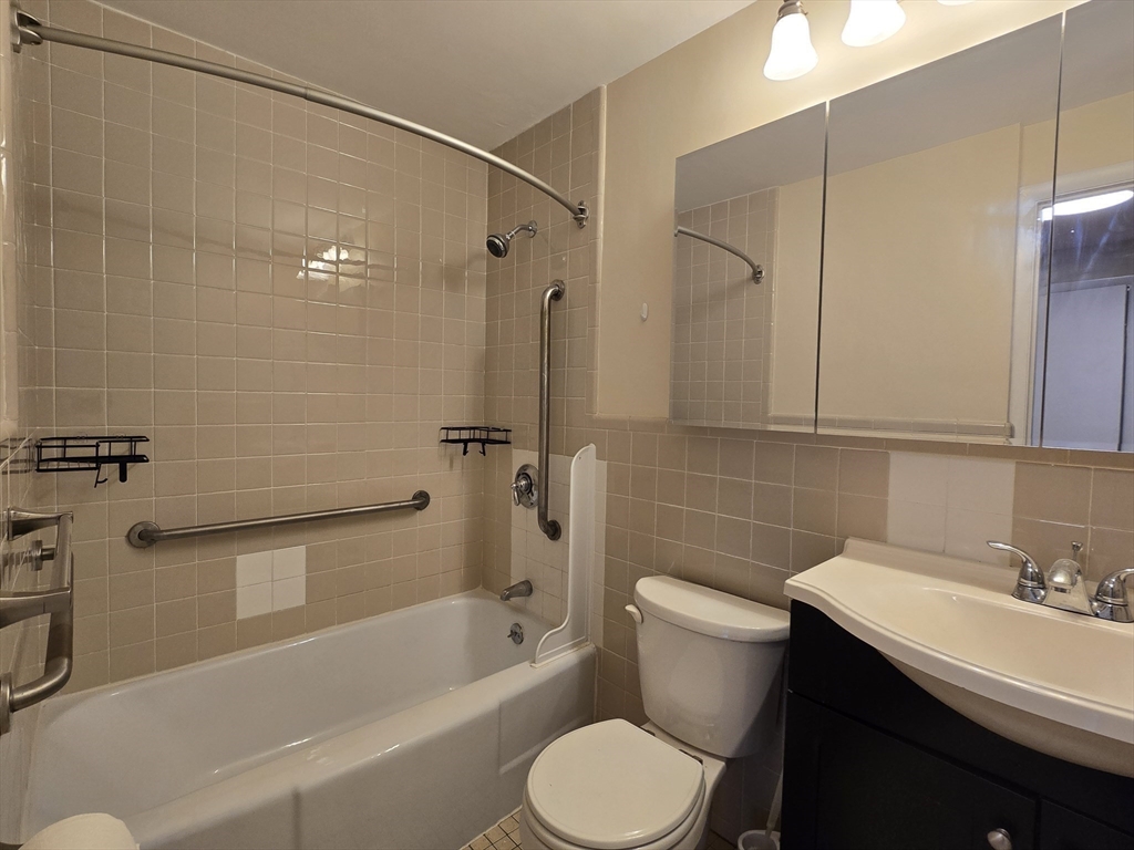 114 Pleasant Street, Unit 306 Arlington, MA 02476 - Photo 12 of 16 a bathroom with a sink toilet and shower