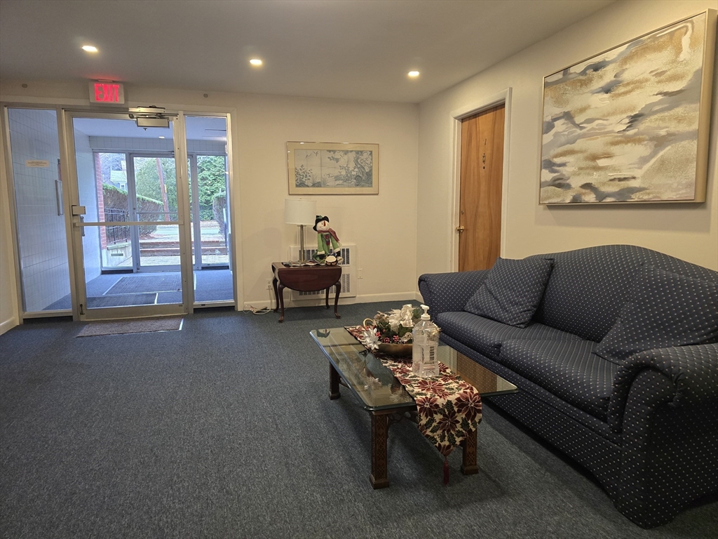 114 Pleasant Street, Unit 306 Arlington, MA 02476 - Photo 13 of 16 a living room with furniture and large window