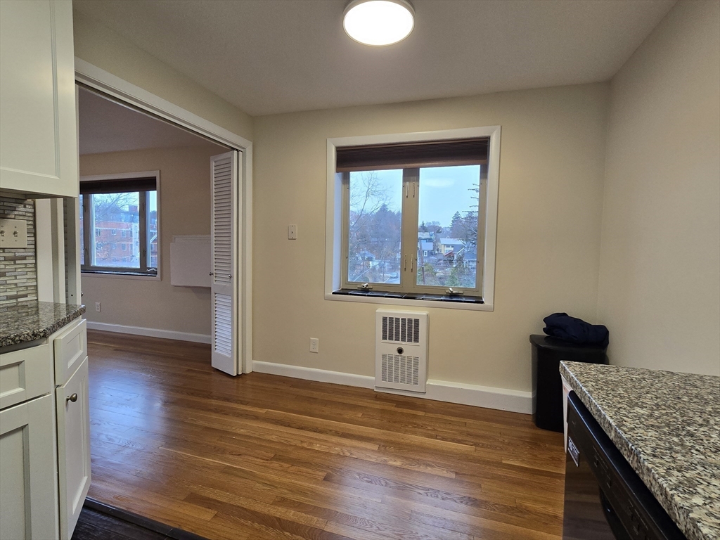 114 Pleasant Street, Unit 306 Arlington, MA 02476 - Photo 5 of 16 a view of kitchen with window wooden floor and cabinet