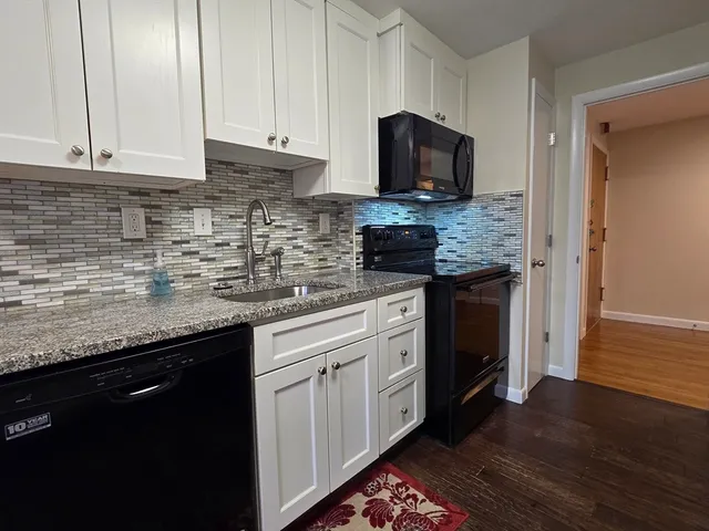 a kitchen with stainless steel appliances granite countertop a sink stove and microwave
