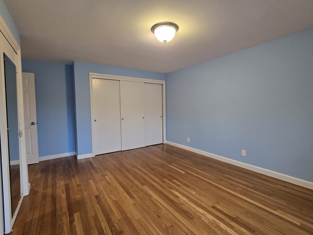 114 Pleasant Street, Unit 306 Arlington, MA 02476 - Photo 10 of 16 a view of an empty room with wooden floor