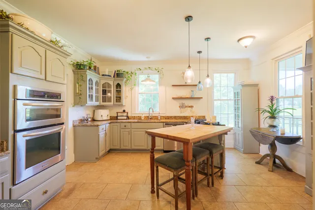 a kitchen with a stove a refrigerator and a dining table