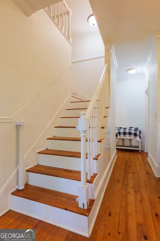 a view of a hallway with wooden floor and staircase