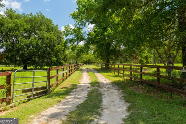 an aerial view of residential houses with outdoor space and trees all around