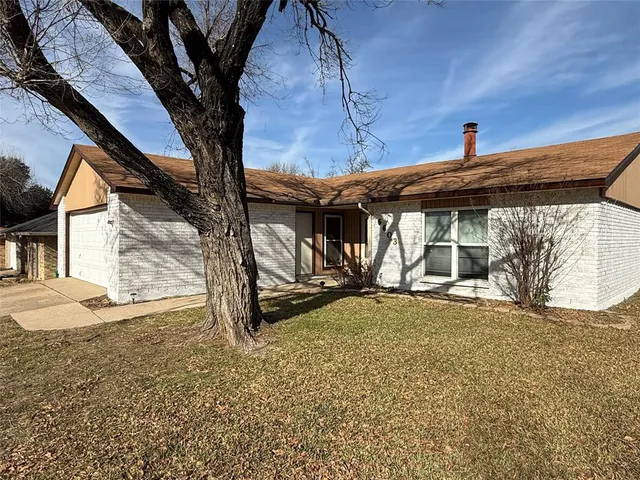 a backyard of a house with barbeque oven and large trees
