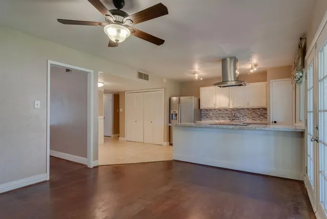 a open kitchen with white cabinets and chandelier