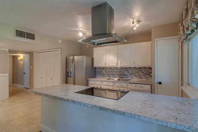a kitchen with stainless steel appliances kitchen island a refrigerator and a sink