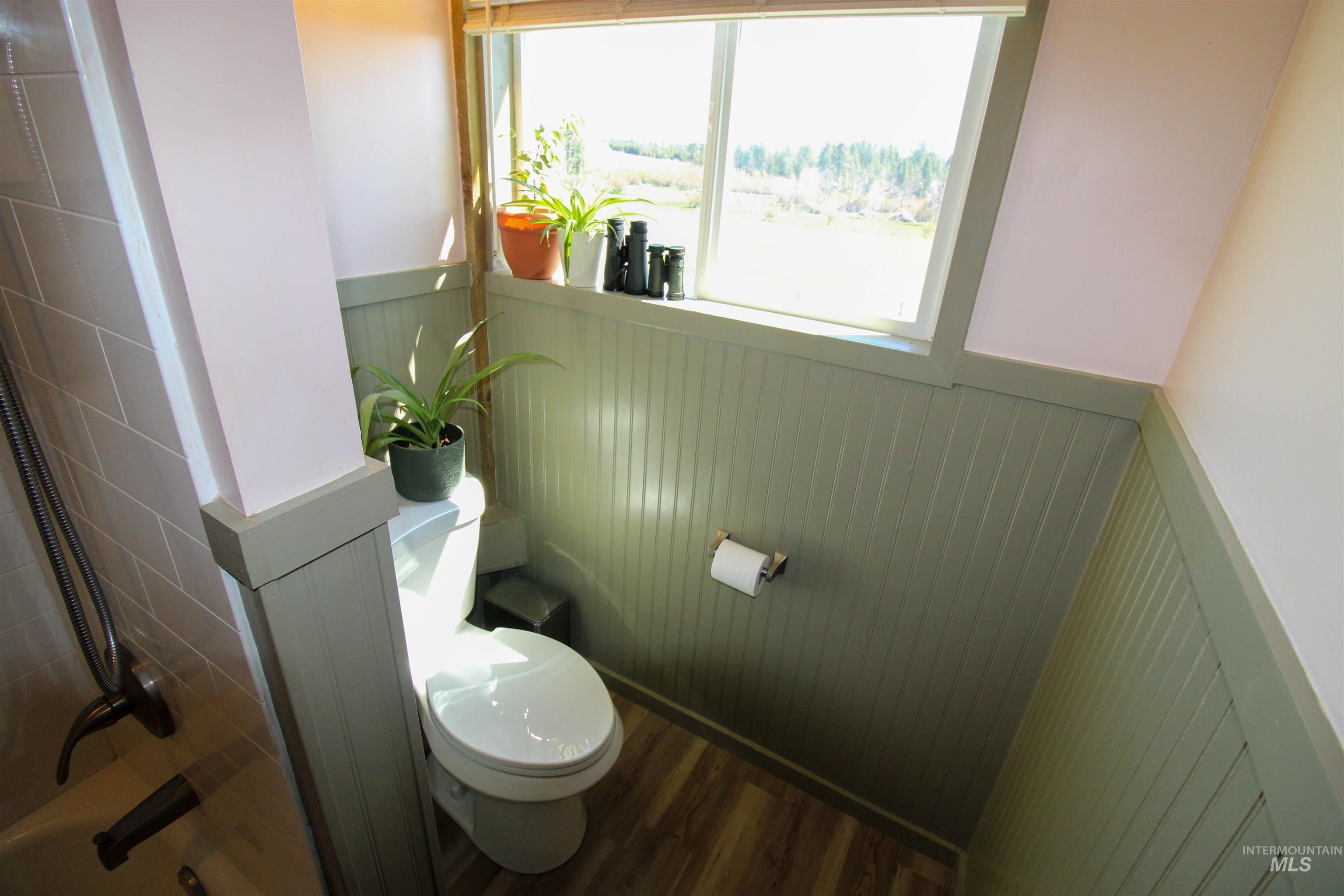 1254 Stuart Road Orofino, ID 83544 - Photo 13 of 48 Bathroom featuring a window, wood-finish flooring, and beadboard wainscoting