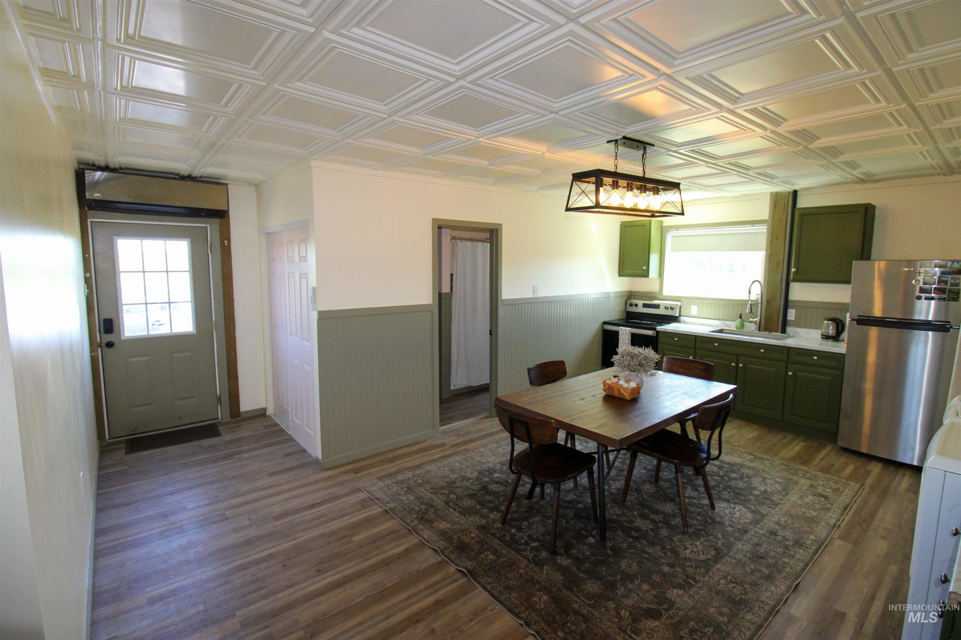 1254 Stuart Road Orofino, ID 83544 - Photo 15 of 48 Kitchen area featuring wood-finish flooring, a decorative coffered ceiling, green cabinetry, white countertops, and stainless steel appliances