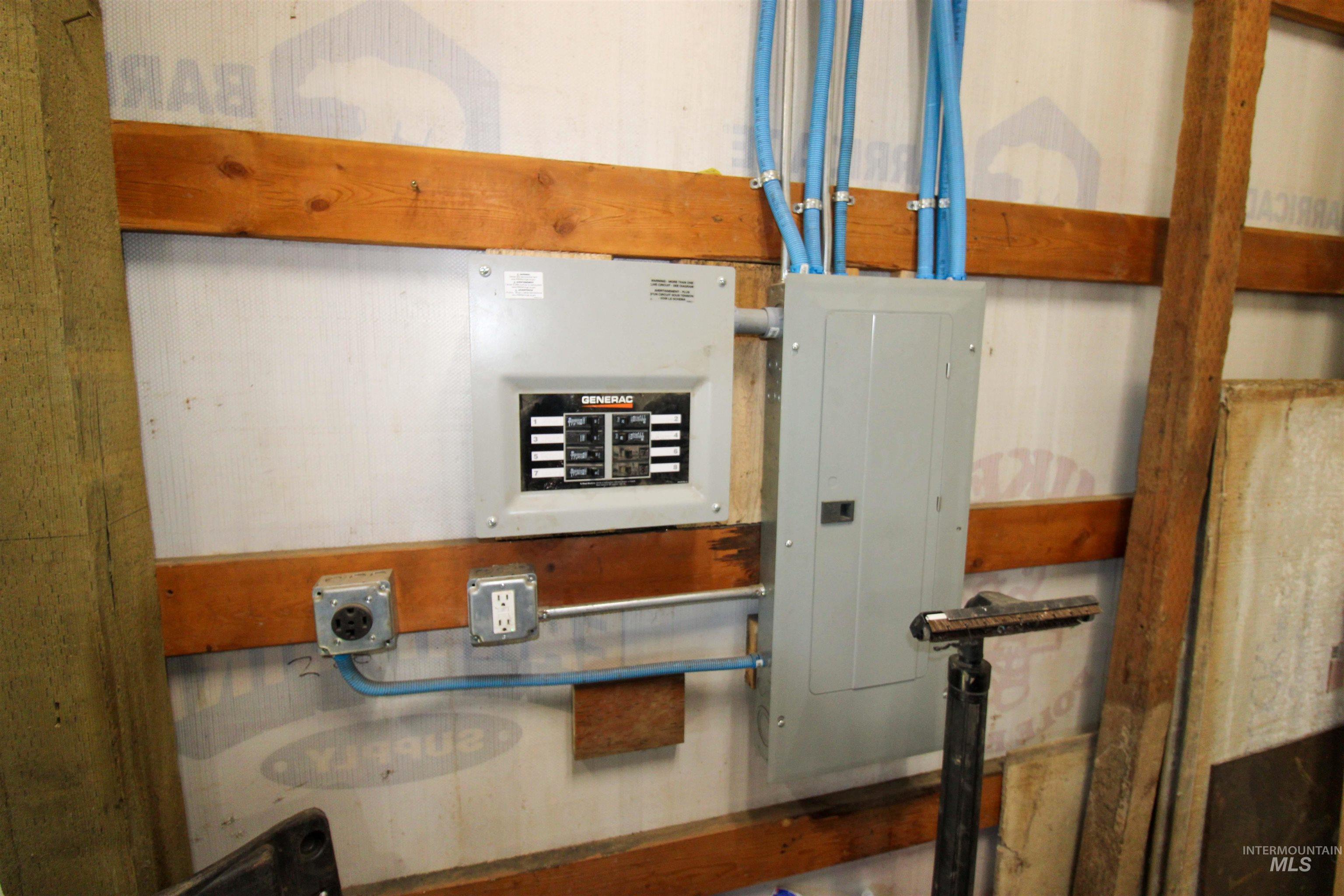 1254 Stuart Road Orofino, ID 83544 - Photo 18 of 48 Electrical panel with generator transfer switch and conduit, mounted on a wall with wooden studs