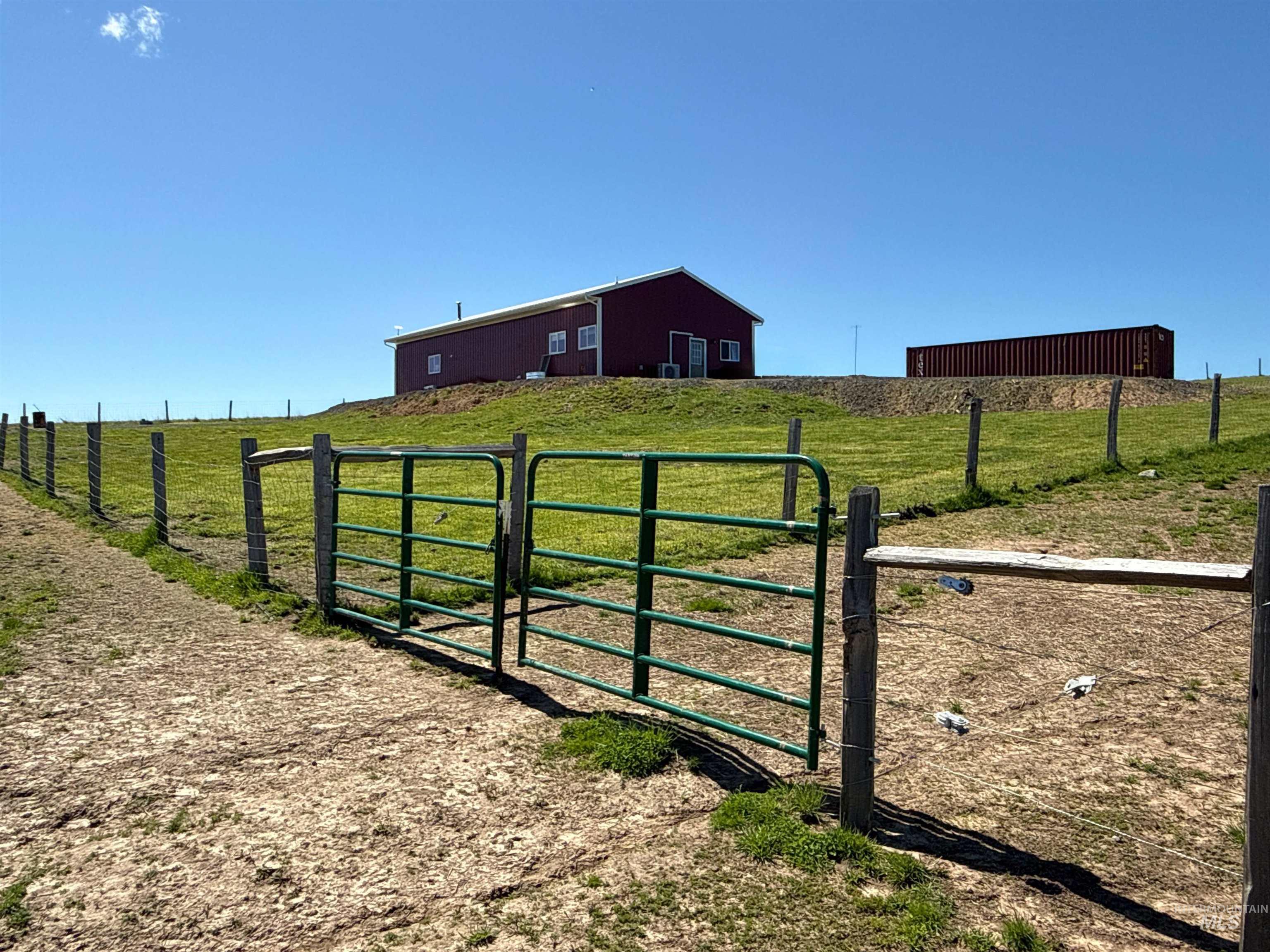 1254 Stuart Road Orofino, ID 83544 - Photo 22 of 48 Expansive open land featuring a red structure with white trim, a separate storage container, and perimeter fencing
